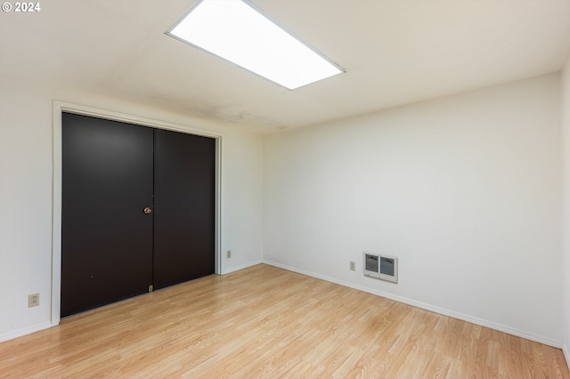 unfurnished bedroom with a closet and light hardwood / wood-style flooring