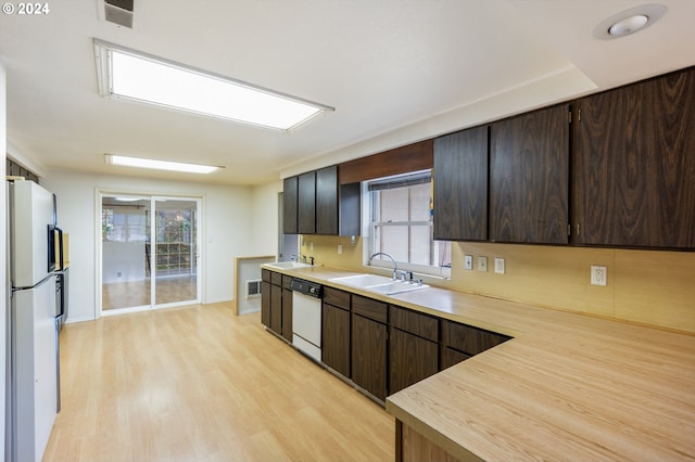 kitchen featuring light hardwood / wood-style floors, a healthy amount of sunlight, white appliances, and sink