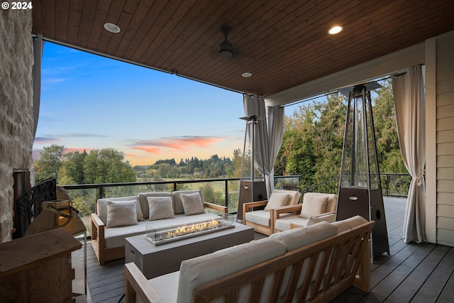 deck at dusk with an outdoor living space with a fire pit