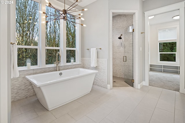 bathroom featuring tile patterned floors, tile walls, plus walk in shower, and a chandelier