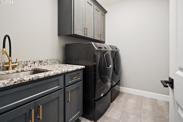 laundry room featuring cabinets, washing machine and dryer, and sink