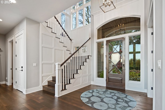 entryway featuring dark wood-type flooring and an inviting chandelier