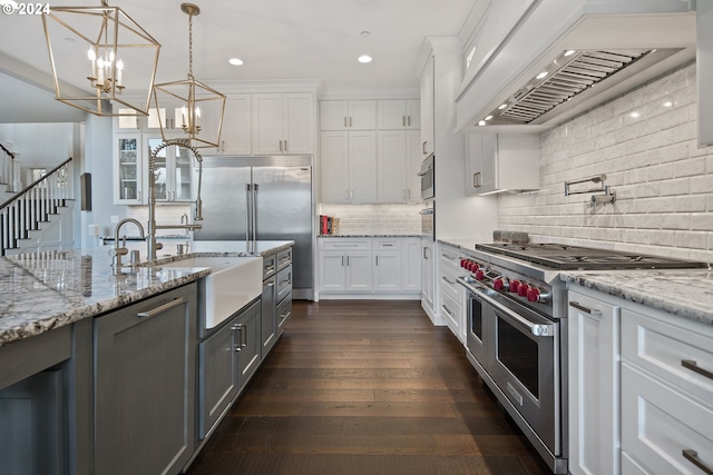 kitchen with dark wood-type flooring, premium appliances, premium range hood, backsplash, and white cabinets