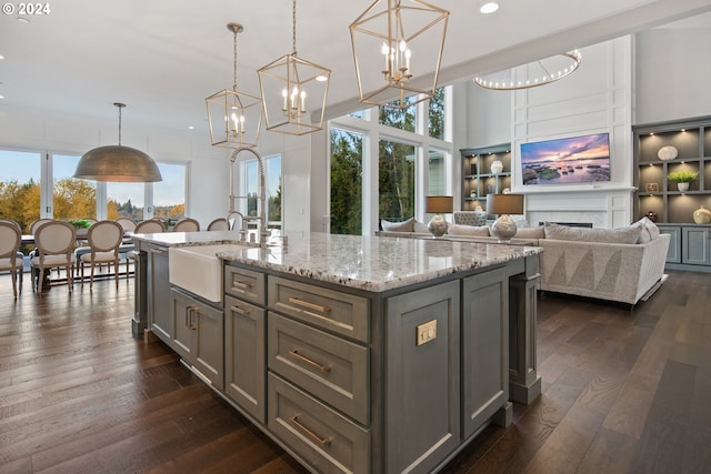 kitchen featuring pendant lighting, dark hardwood / wood-style flooring, and an island with sink