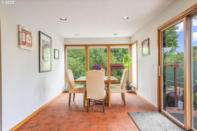 dining room with dark tile patterned floors, recessed lighting, and a textured ceiling