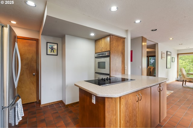 kitchen featuring light countertops, recessed lighting, brown cabinets, and stainless steel appliances