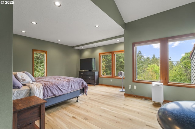 bedroom with recessed lighting, multiple windows, wood finished floors, and baseboards