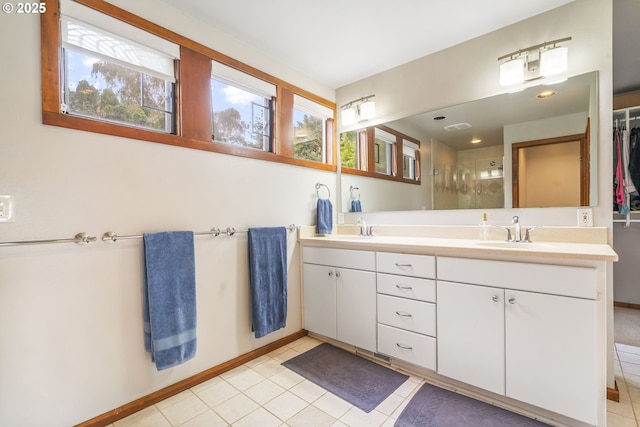 full bathroom featuring tile patterned flooring, double vanity, a stall shower, and a sink