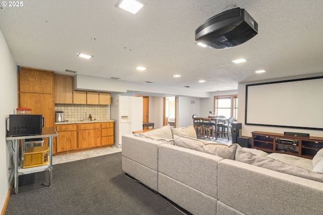 home theater room featuring visible vents, dark carpet, recessed lighting, a textured ceiling, and a sink