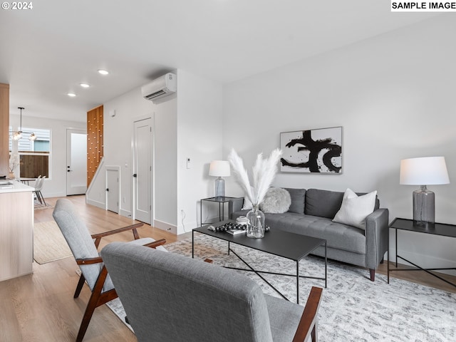 living room with light hardwood / wood-style floors and a wall mounted AC