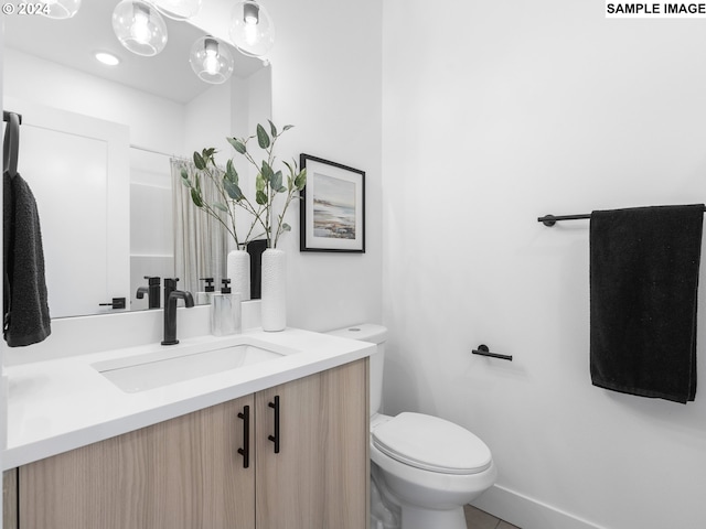 bathroom with tile patterned flooring, vanity, and toilet