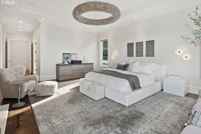 bedroom with ornamental molding, a raised ceiling, and hardwood / wood-style floors