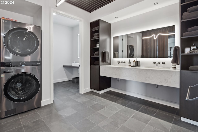 bathroom featuring stacked washing maching and dryer, vanity, and tile patterned floors