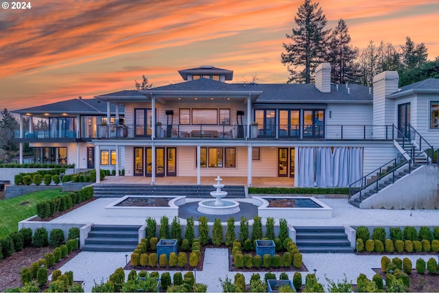 back house at dusk with a balcony