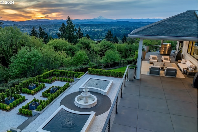 patio terrace at dusk with an outdoor hangout area and a mountain view