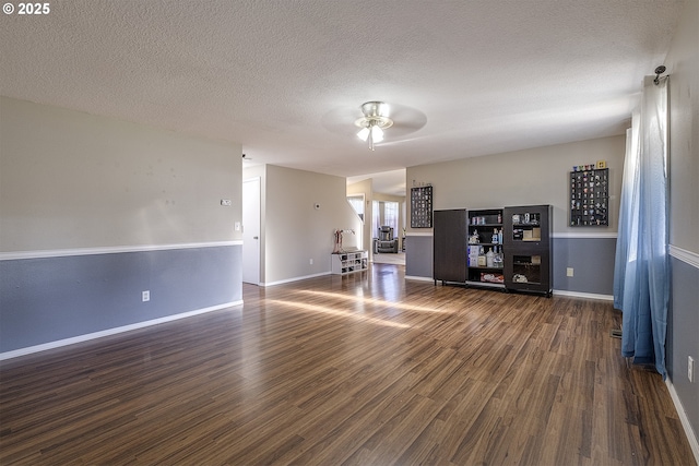 interior space with a textured ceiling, dark hardwood / wood-style floors, and ceiling fan