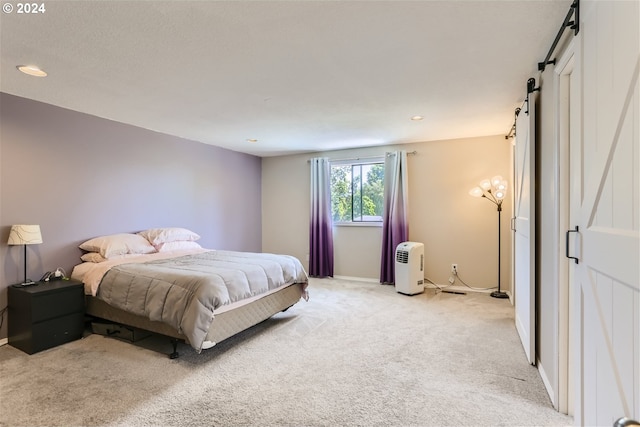 carpeted bedroom featuring a barn door