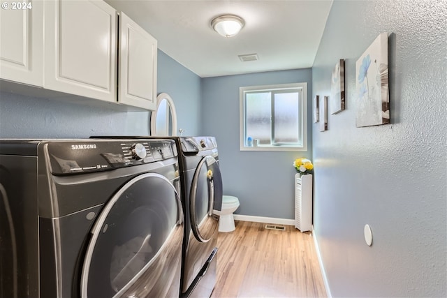 washroom with light wood-type flooring and washing machine and clothes dryer