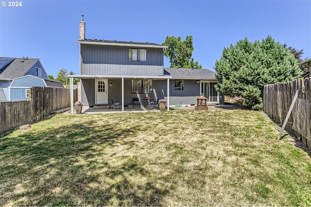 rear view of property featuring a patio and a yard