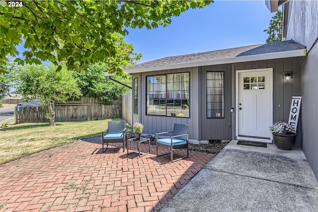 entrance to property with a patio and a yard