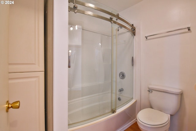 full bathroom featuring toilet and bath / shower combo with glass door