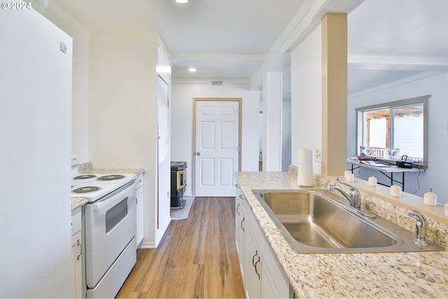 kitchen with visible vents, a sink, white appliances, white cabinets, and light wood finished floors