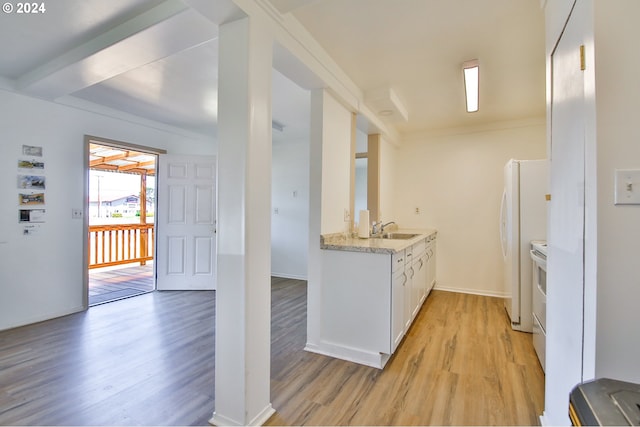 kitchen featuring light stone counters, light wood-style flooring, white appliances, white cabinetry, and a sink