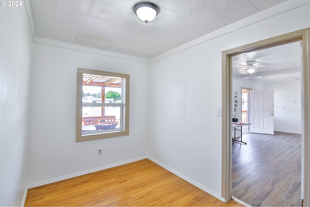 spare room with baseboards and light wood-style floors