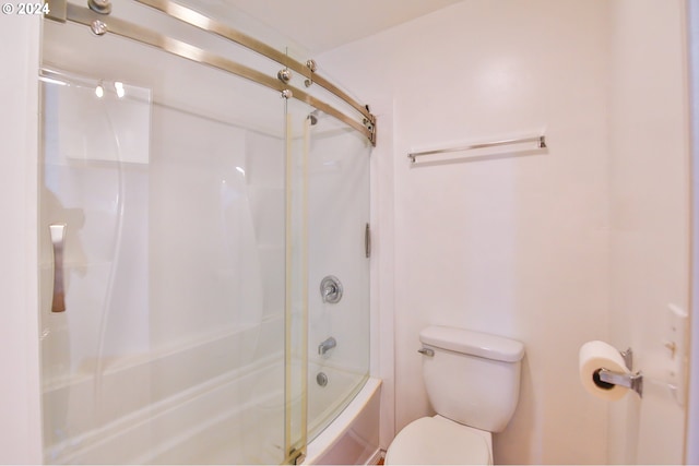 bathroom featuring toilet and combined bath / shower with glass door