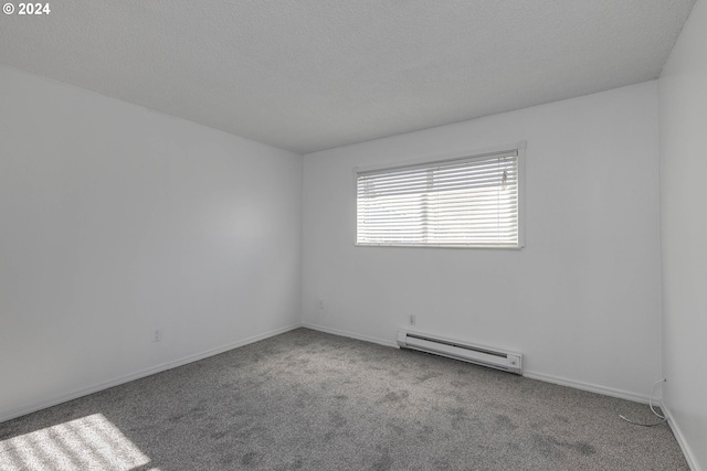 carpeted empty room featuring a textured ceiling and baseboard heating