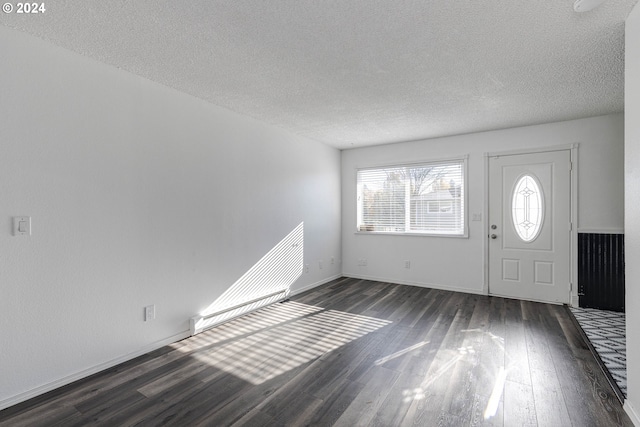 entryway with dark wood-type flooring and a textured ceiling