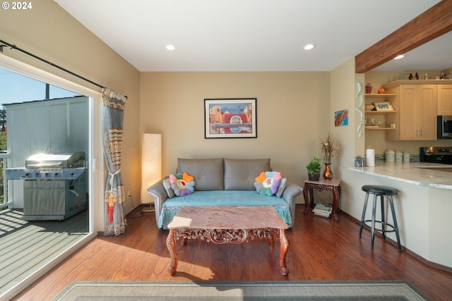 living room with beamed ceiling and dark wood-type flooring