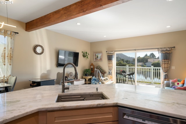 kitchen with sink, beam ceiling, black dishwasher, light stone countertops, and decorative light fixtures