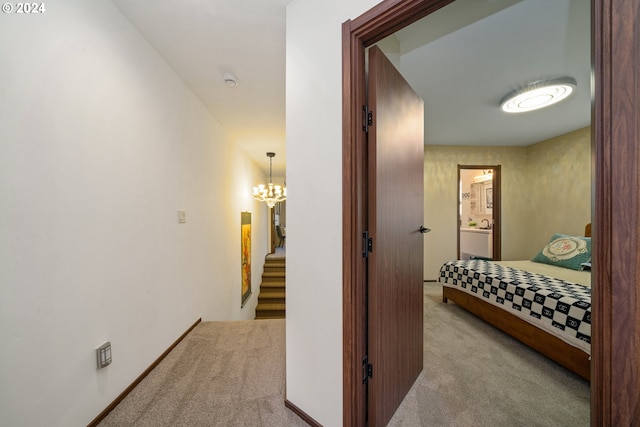 bedroom featuring an inviting chandelier and light colored carpet