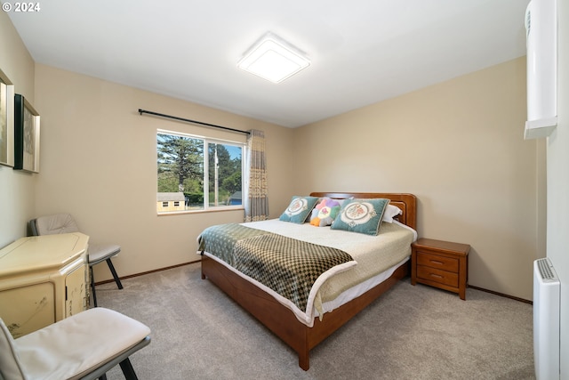 bedroom with radiator heating unit and light colored carpet