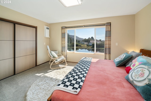 bedroom featuring a water view and carpet