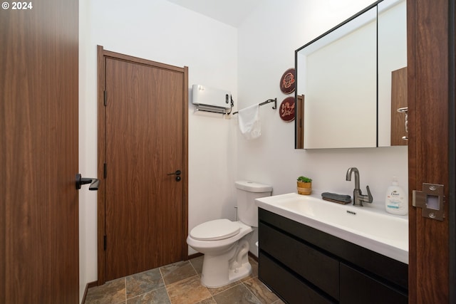 bathroom with vanity, an AC wall unit, and toilet