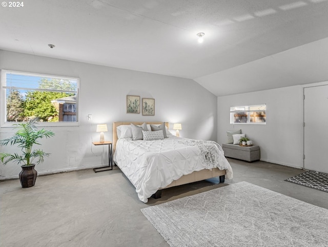 bedroom featuring concrete flooring and lofted ceiling