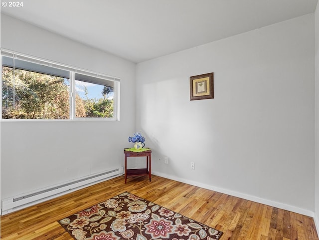 sitting room with hardwood / wood-style floors and baseboard heating