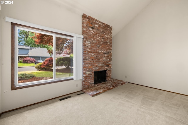 unfurnished living room featuring carpet floors, lofted ceiling, and a brick fireplace