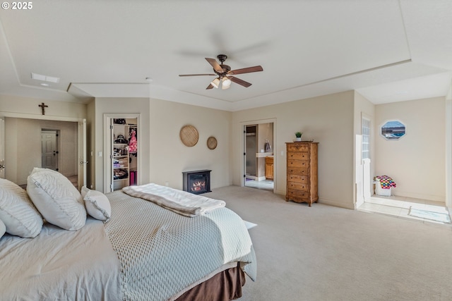 carpeted bedroom with a closet, ceiling fan, and a spacious closet