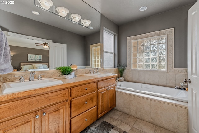 bathroom with tiled bath, tile patterned floors, vanity, and ceiling fan