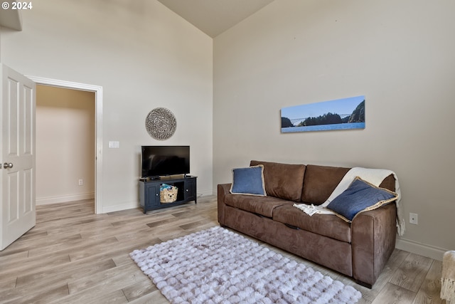 living room with high vaulted ceiling and light hardwood / wood-style flooring