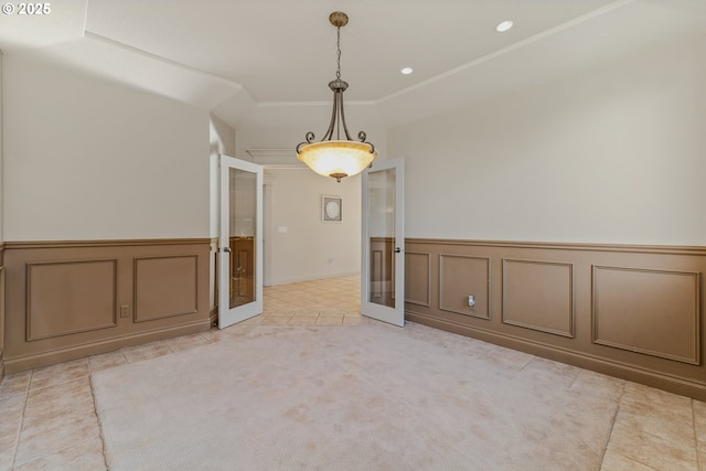 unfurnished room with light tile patterned flooring, french doors, and a tray ceiling