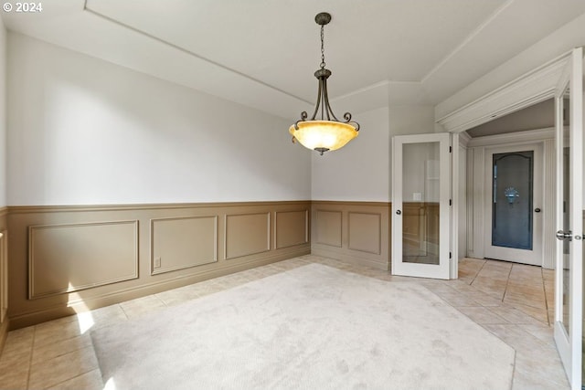 tiled empty room featuring french doors