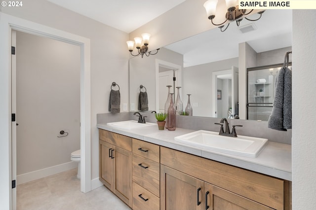 bathroom featuring vanity, toilet, and a chandelier