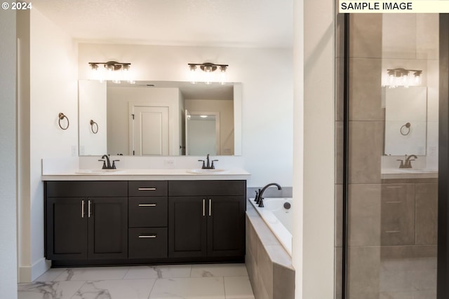 bathroom with tiled tub and vanity