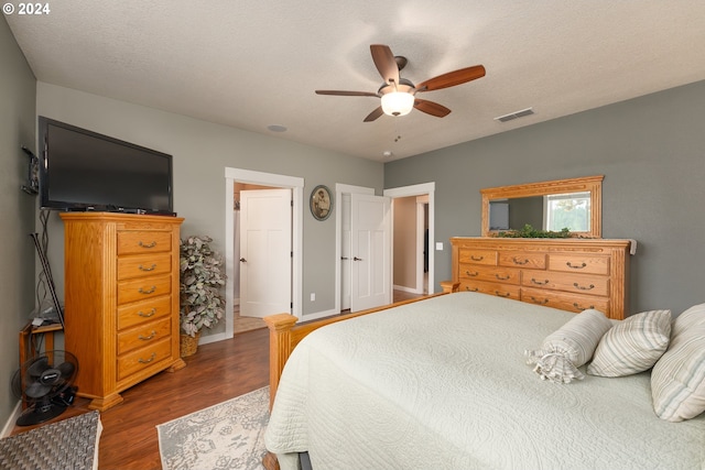 bedroom featuring dark hardwood / wood-style floors, a textured ceiling, and ceiling fan