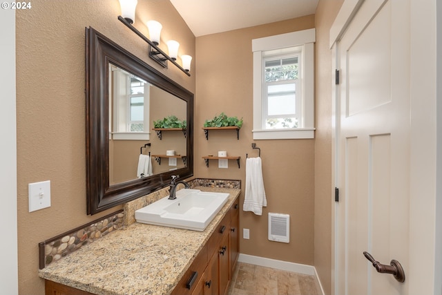 bathroom with heating unit and vanity