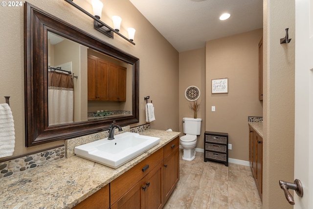 bathroom featuring wood-type flooring, vanity, and toilet